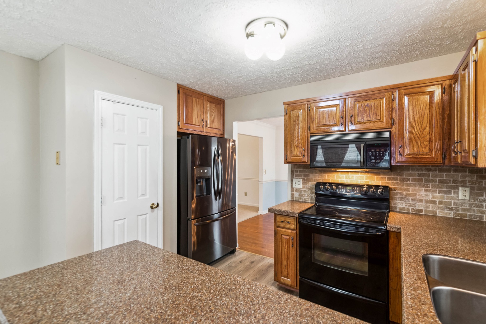 4105 New Hope Meadow Road Hermitage, TN 37076 - Photo 11 of 45 a kitchen with stainless steel appliances granite countertop a stove a refrigerator and a stove top oven