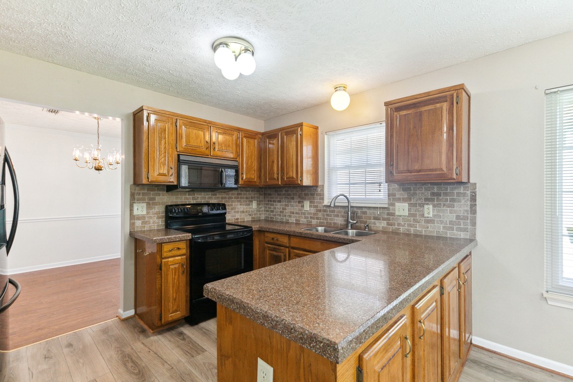 4105 New Hope Meadow Road Hermitage, TN 37076 - Photo 12 of 45 a kitchen with stainless steel appliances granite countertop a sink stove microwave and refrigerator