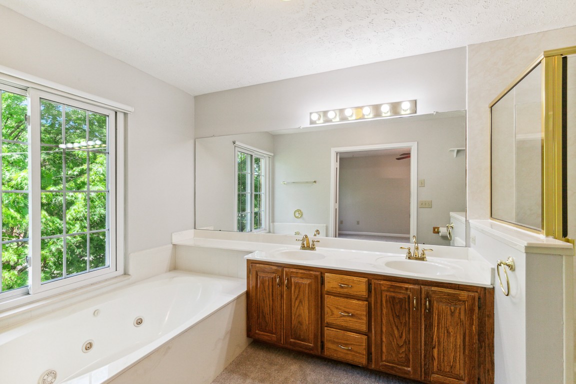 4105 New Hope Meadow Road Hermitage, TN 37076 - Photo 16 of 45 a bathroom with a double vanity sink a large mirror and a bathtub