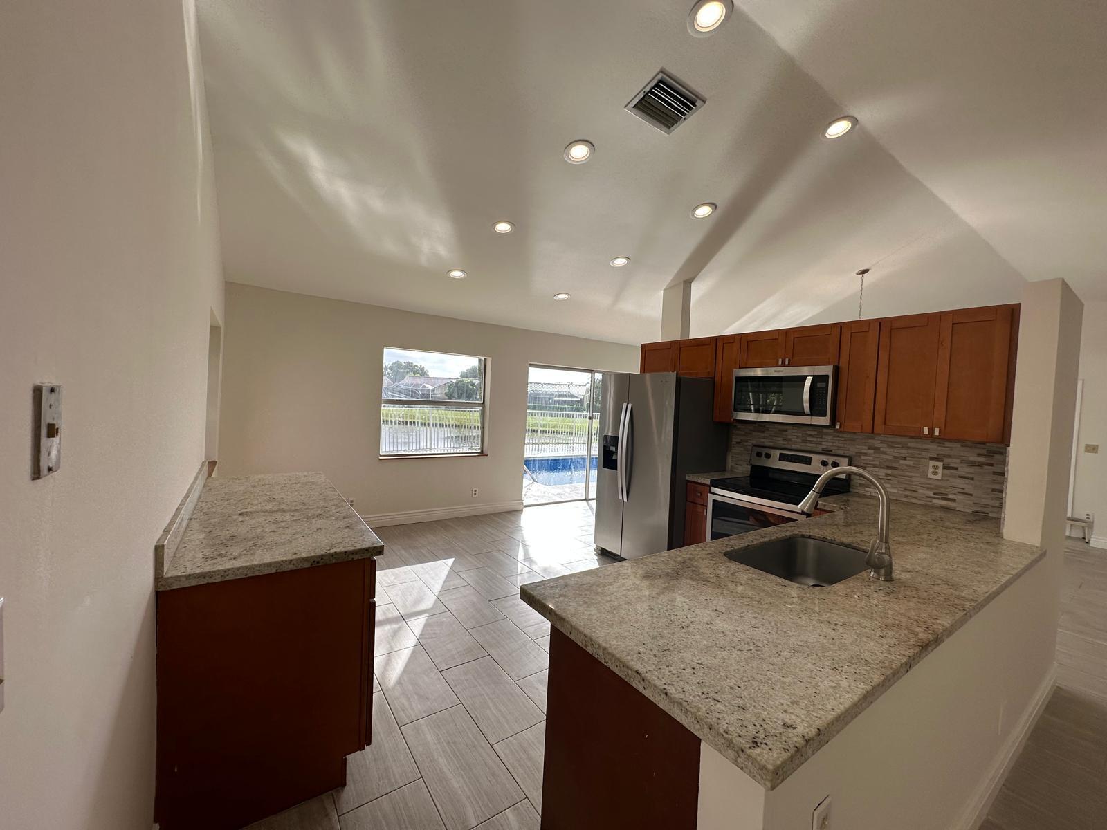 9841 Ridge Creek Road Boca Raton, FL 33496 - Photo 17 of 24 a kitchen with stainless steel appliances granite countertop a sink and stove