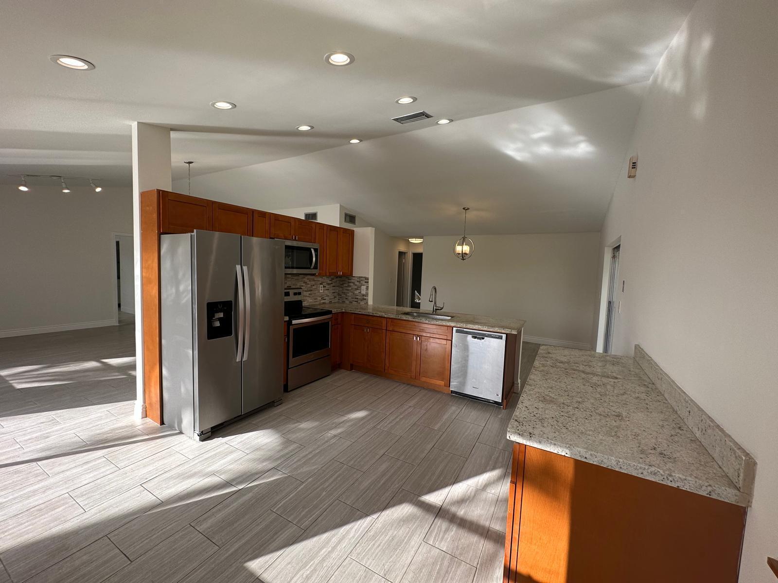 9841 Ridge Creek Road Boca Raton, FL 33496 - Photo 18 of 24 a large kitchen with stainless steel appliances kitchen island a large counter top