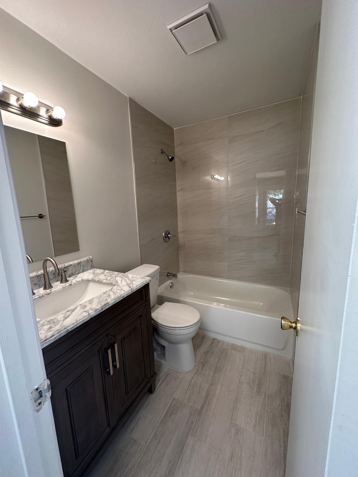 9841 Ridge Creek Road Boca Raton, FL 33496 - Photo 10 of 24 a bathroom with a granite countertop sink toilet a mirror and shower