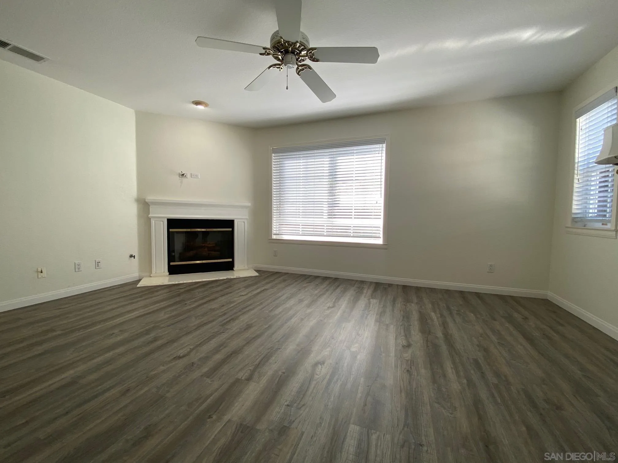 2848 Torrey Pines Road La Jolla, CA 92037 - Photo 11 of 19 an empty room with wooden floor fireplace and windows
