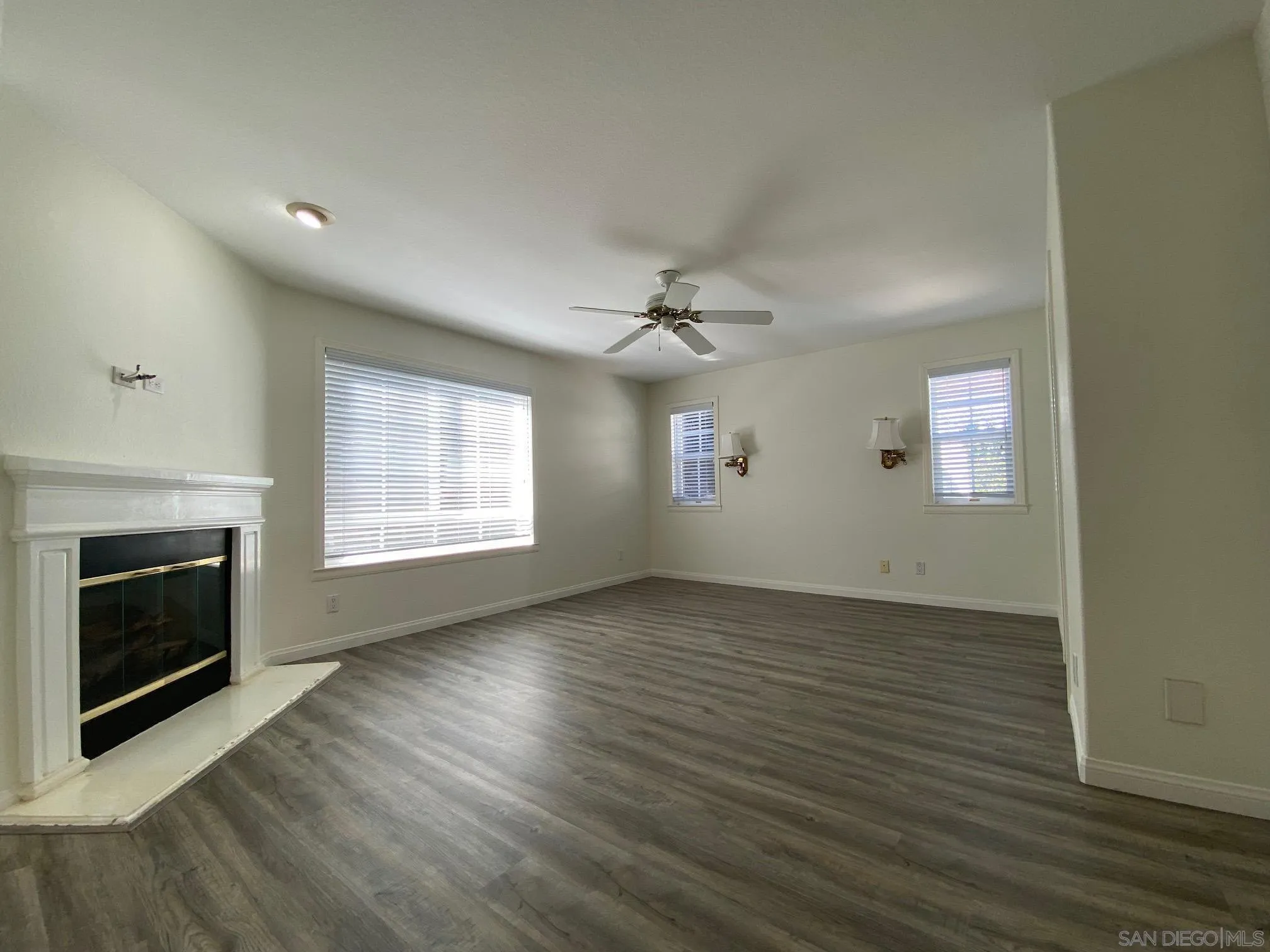 2848 Torrey Pines Road La Jolla, CA 92037 - Photo 10 of 19 an empty room with wooden floor fireplace and windows