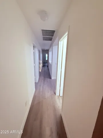 a view of a hallway with wooden floor