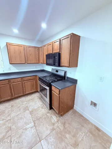 a kitchen with stainless steel appliances granite countertop a stove a sink and a microwave