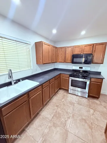 a kitchen with stainless steel appliances granite countertop a sink stove and cabinets