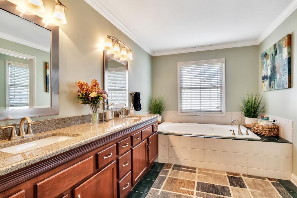 807 Sharp Court Elburn, IL 60119 - Photo 26 of 44 a spacious bathroom with a granite countertop tub a double vanity sink and mirror