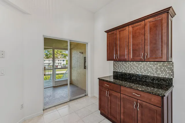 a kitchen with a stove top oven cabinetry and a window
