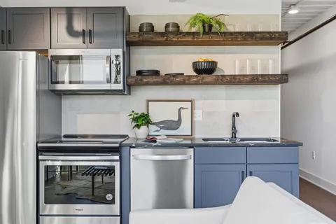 a kitchen with stainless steel appliances granite countertop a stove and white cabinets