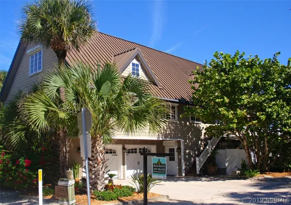 a front view of a house with a tree