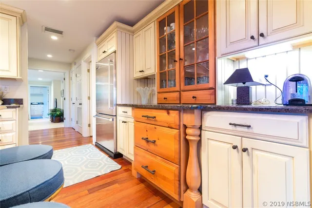 a kitchen with stainless steel appliances kitchen island granite countertop a refrigerator and cabinets