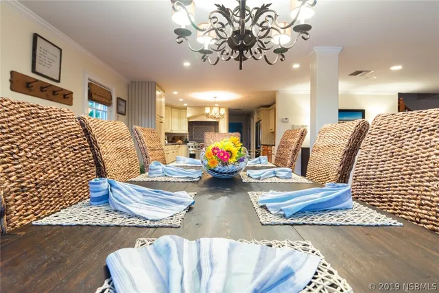 a living room with furniture chandelier and wooden floor