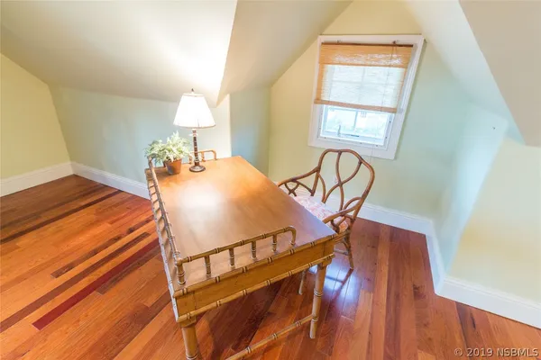 a view of a bedroom with furniture and wooden floor