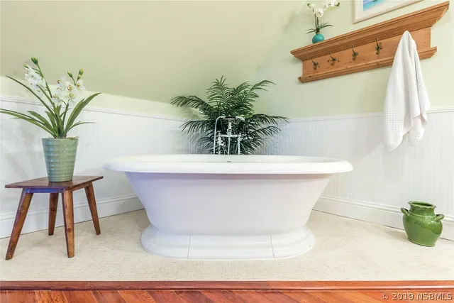 a white vase with flowers on a table