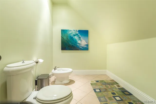 a white toilet sitting next to a white sink and vanity