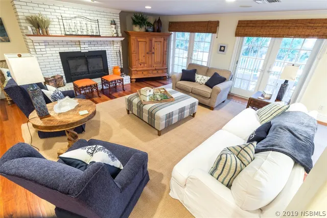 a living room with furniture a fireplace and a large window