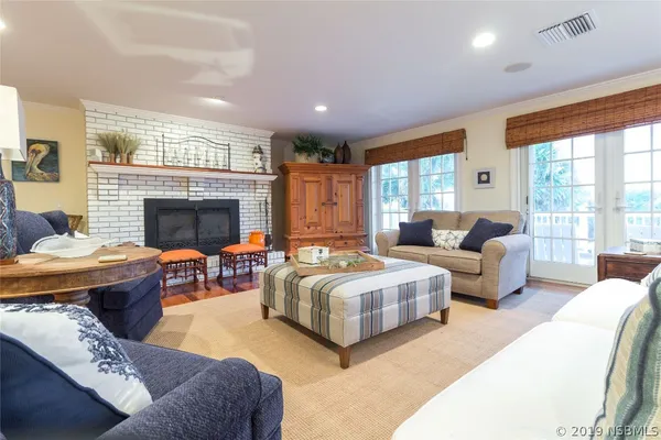 a living room with furniture fireplace and a large window