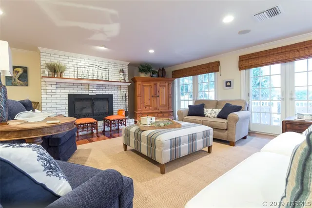 a living room with furniture fireplace and a large window