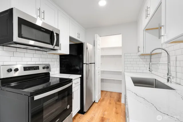 a kitchen with a sink stove and microwave