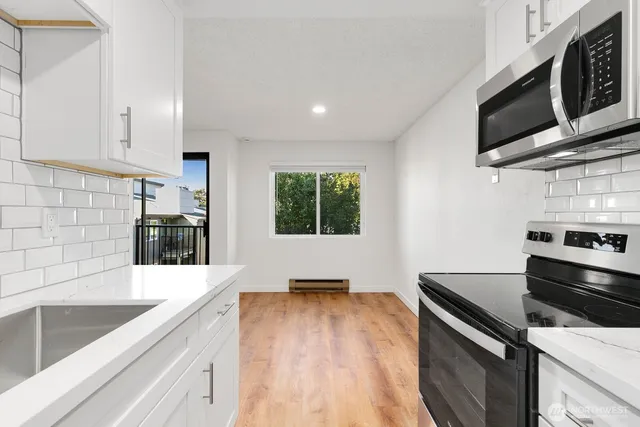 a kitchen with stainless steel appliances a stove microwave and sink