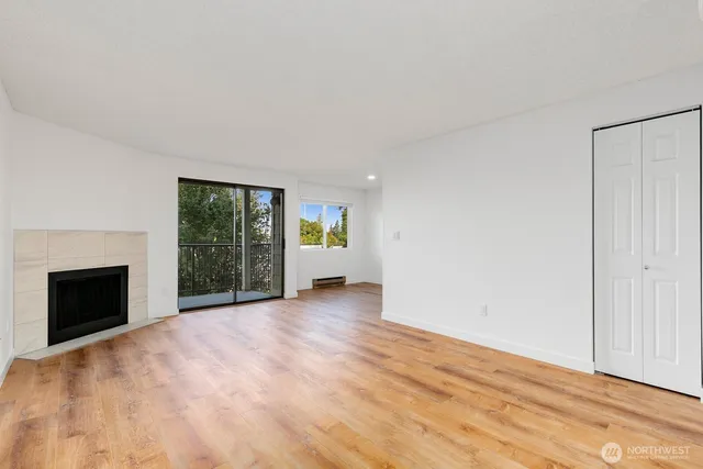 a view of an empty room with a fireplace and a window