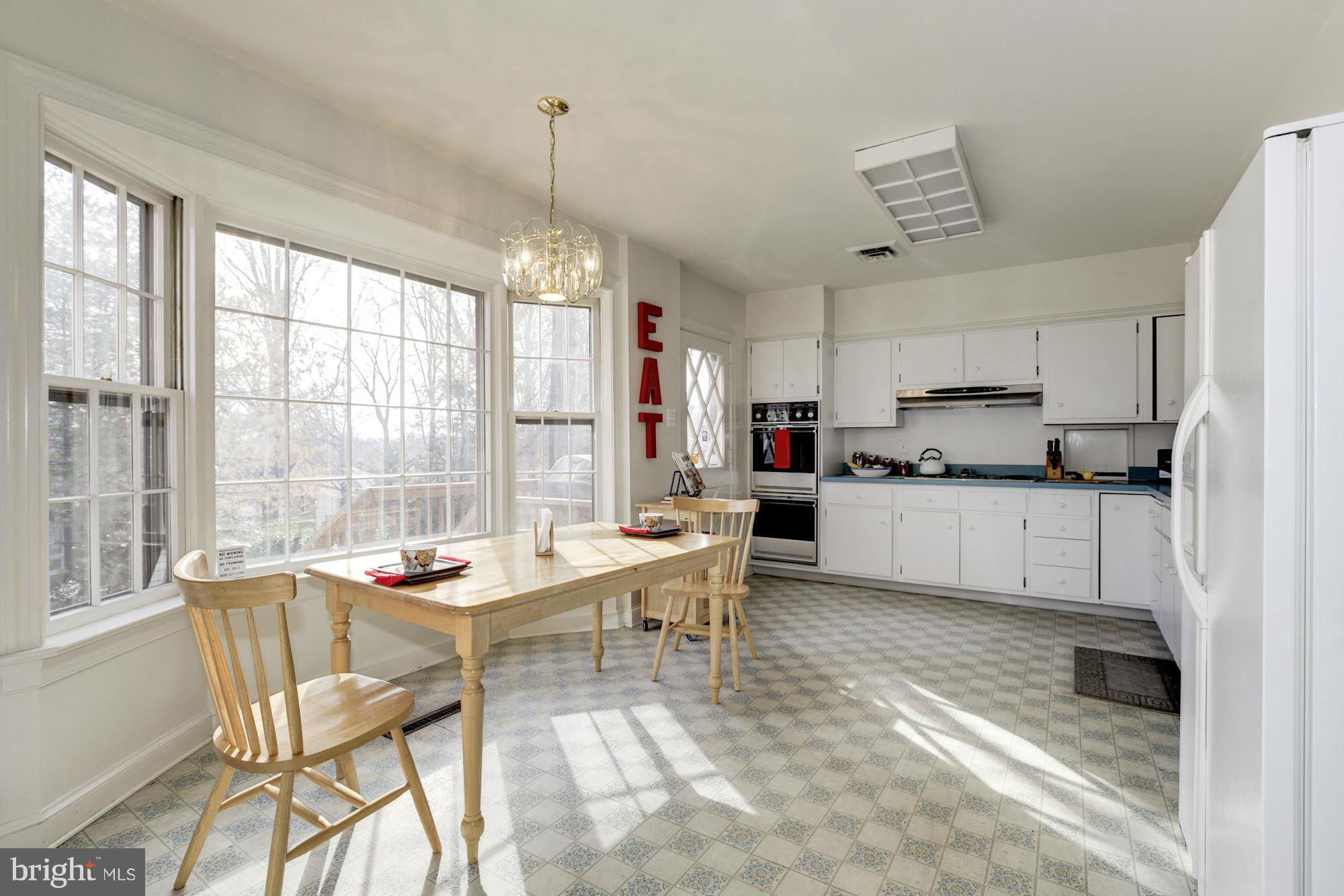 6308 Lenox Road Bethesda, MD 20817 - Photo 10 of 30 a kitchen with a table chairs refrigerator and cabinets