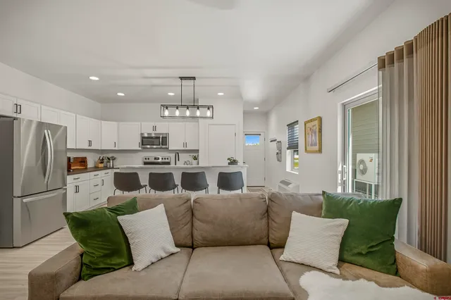 a kitchen with stainless steel appliances kitchen island granite countertop a refrigerator and a fireplace