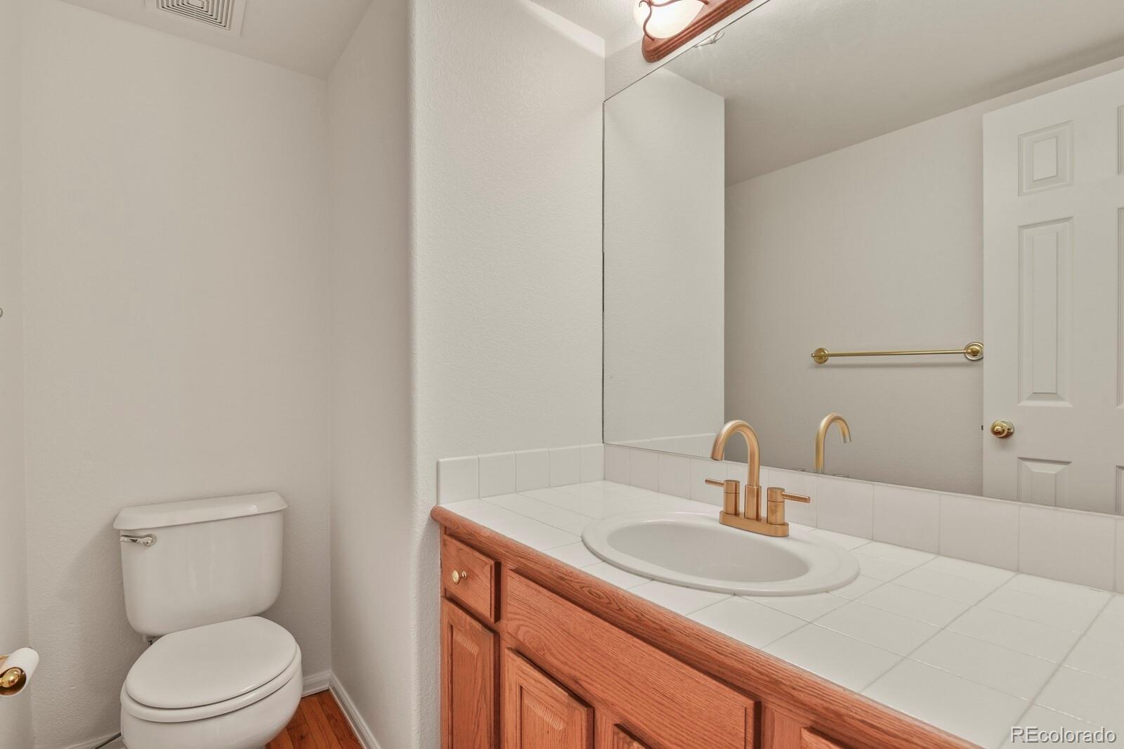 3244 Capstan Way Colorado Springs, CO 80906 - Photo 15 of 37 a bathroom with a toilet sink a mirror and vanity