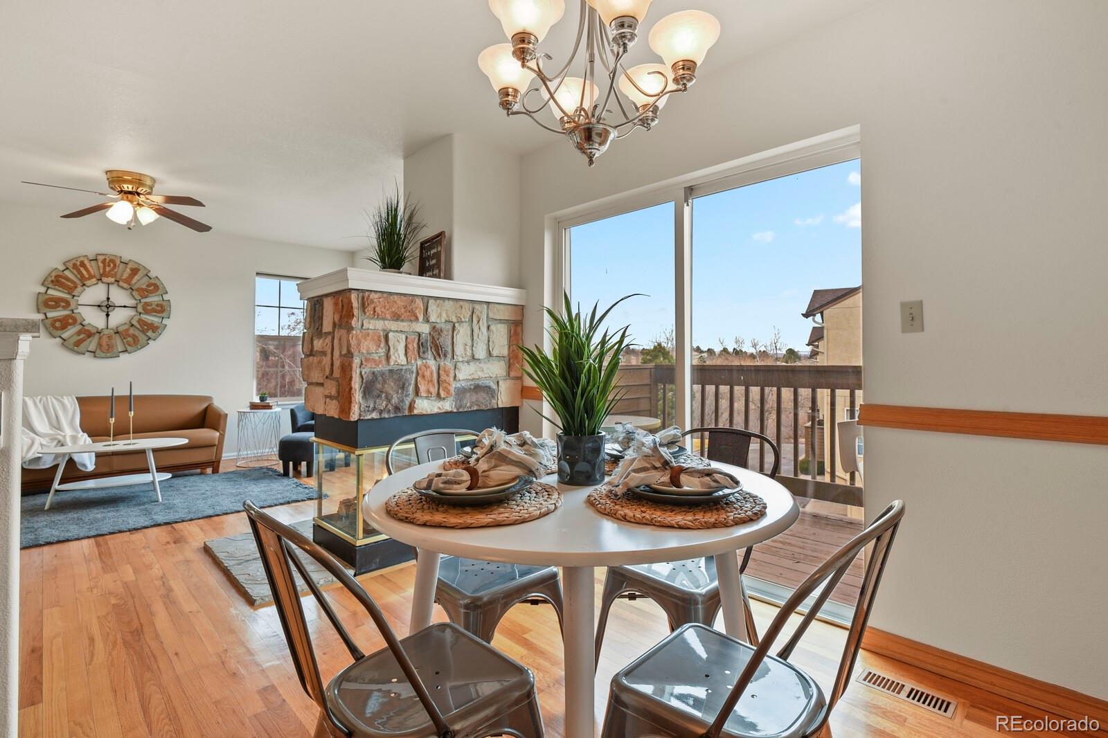 3244 Capstan Way Colorado Springs, CO 80906 - Photo 10 of 37 a view of a dining room with furniture a chandelier and wooden floor