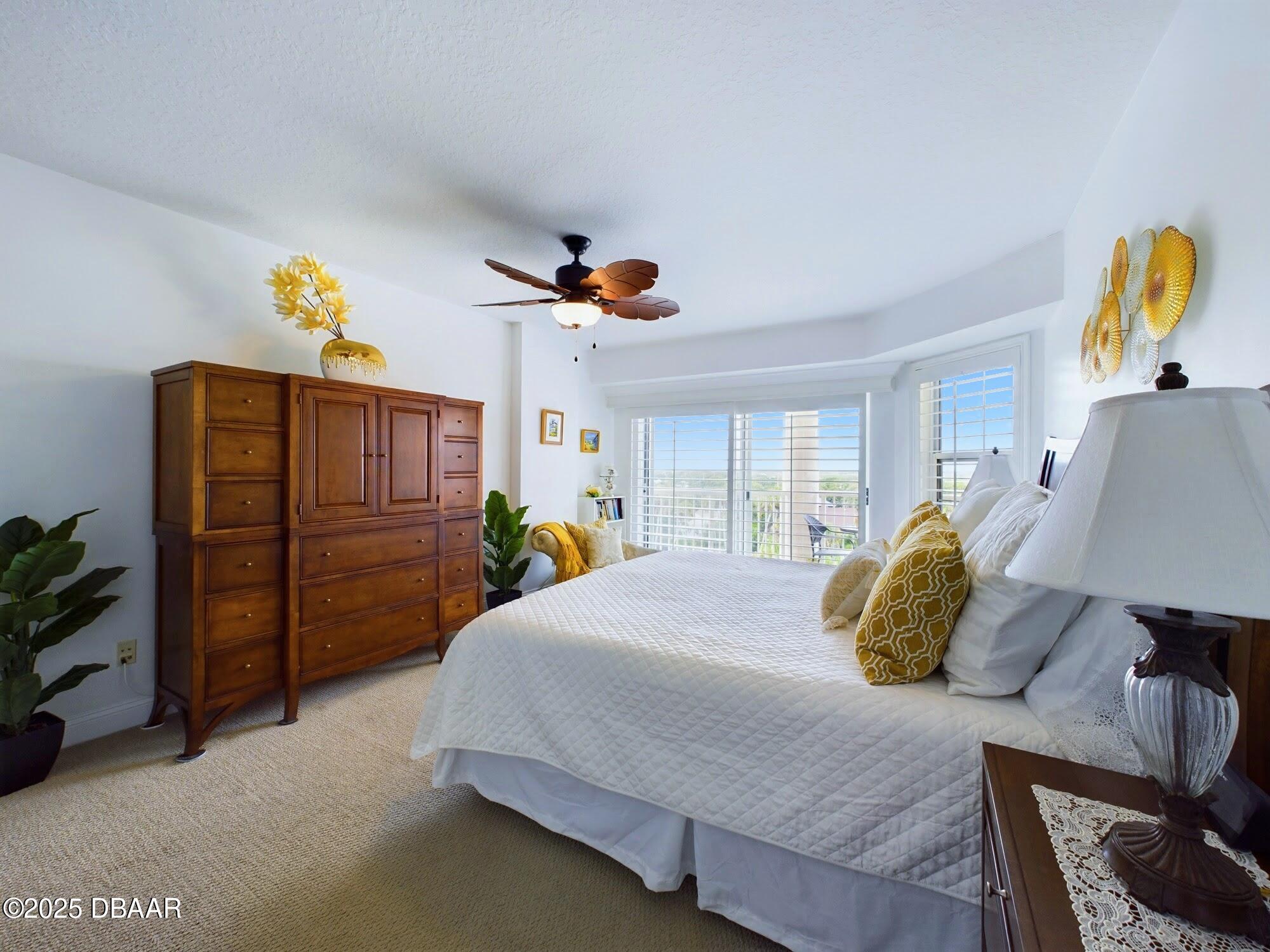 4670 Links Village Drive, Unit C601 Ponce Inlet, FL 32127 - Photo 20 of 68 a bedroom with a bed a dresser and window