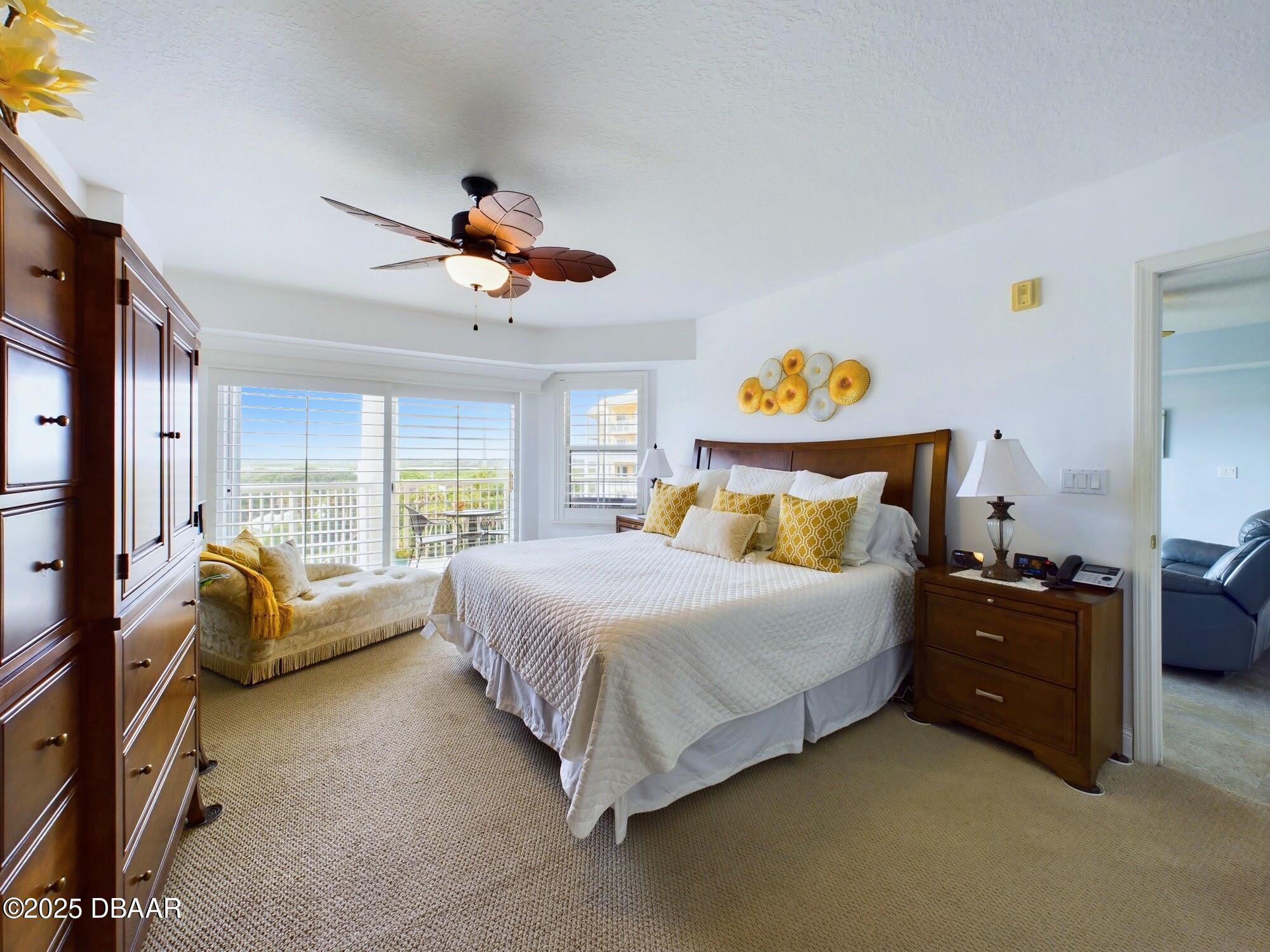 4670 Links Village Drive, Unit C601 Ponce Inlet, FL 32127 - Photo 21 of 68 a spacious bedroom with a bed and a chandelier