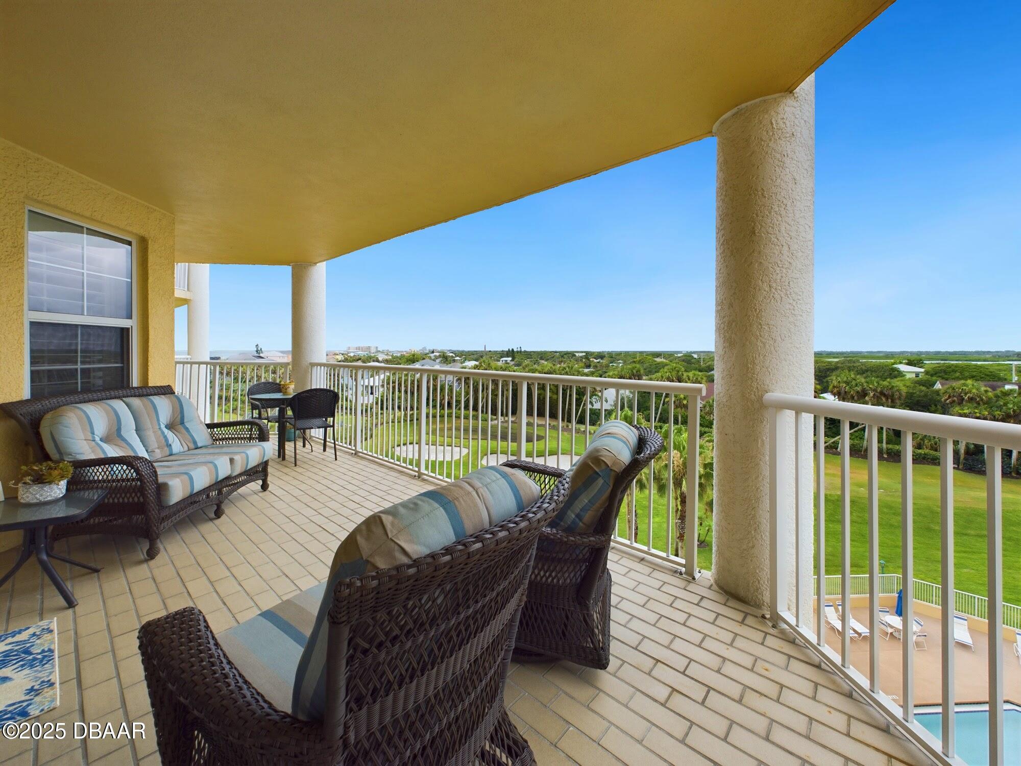 4670 Links Village Drive, Unit C601 Ponce Inlet, FL 32127 - Photo 42 of 68 a view of a patio with couches chairs dining table and chairs