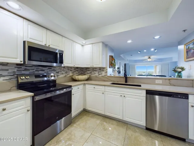 a kitchen with a sink refrigerator and cabinets