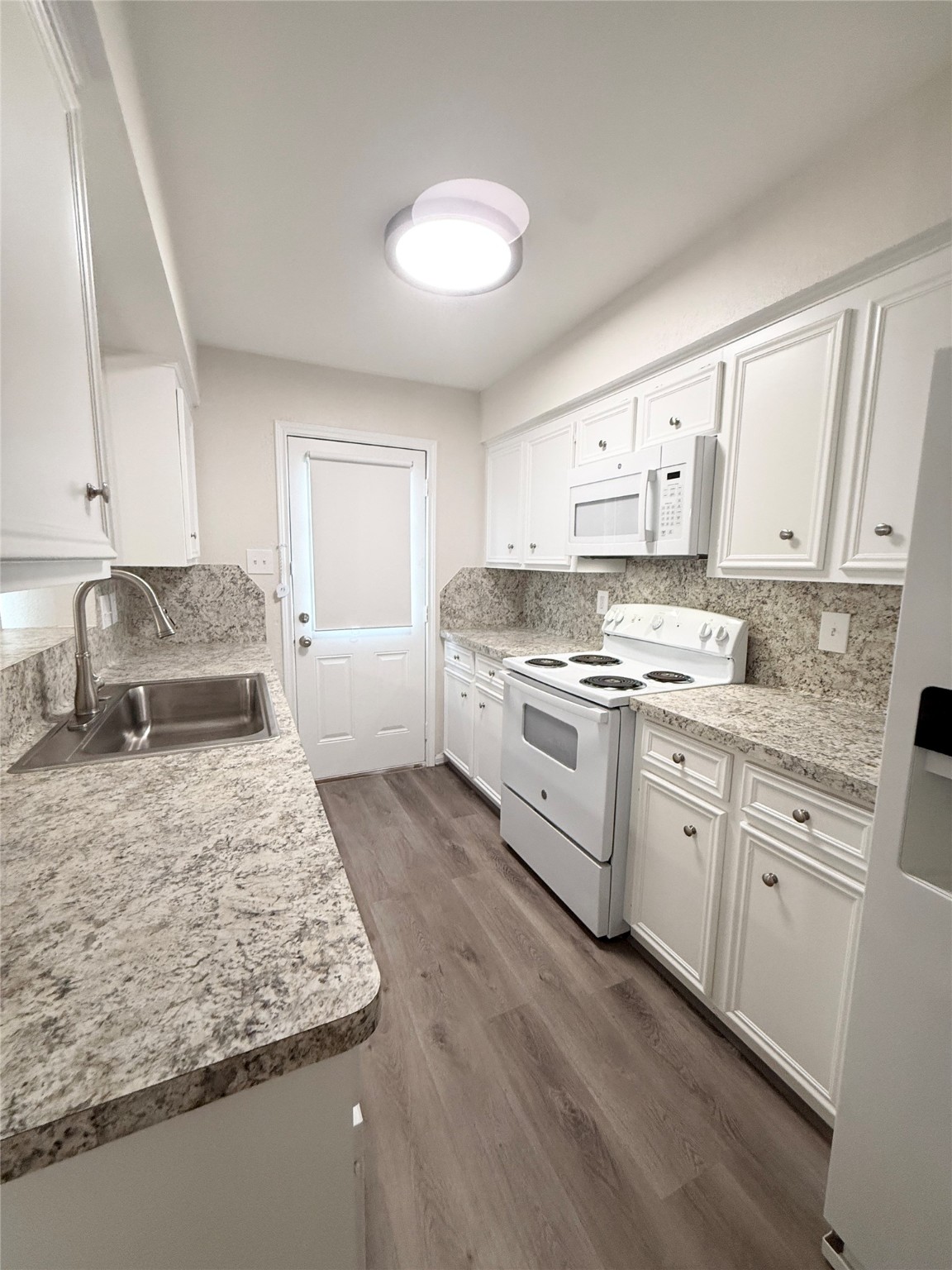 1477 Springrock Lane, Unit 12 Houston, TX 77055 - Photo 11 of 24 a kitchen with stainless steel appliances granite countertop a sink stove and white cabinets