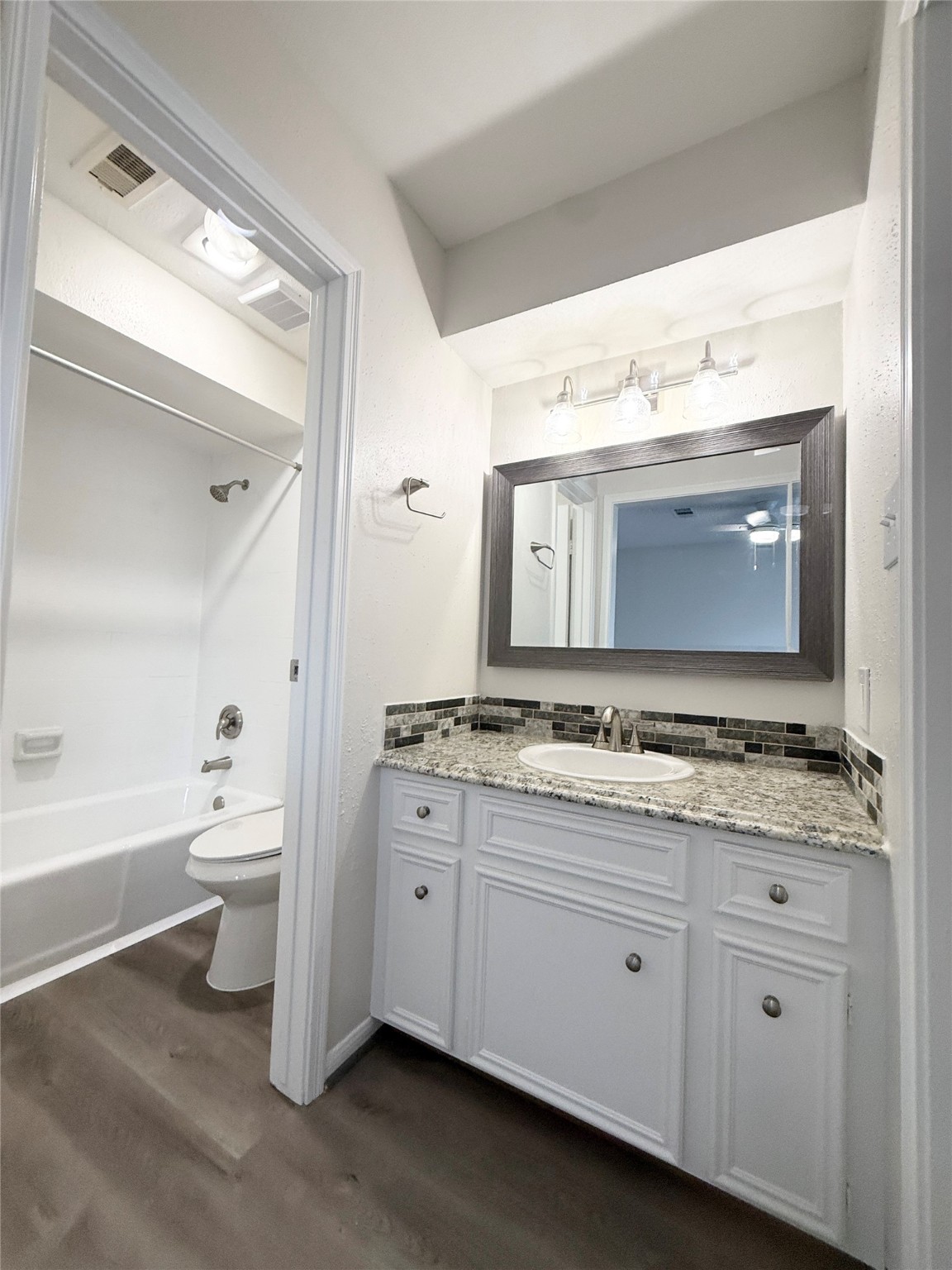 1477 Springrock Lane, Unit 12 Houston, TX 77055 - Photo 21 of 24 a bathroom with a granite countertop sink toilet mirror and bathtub