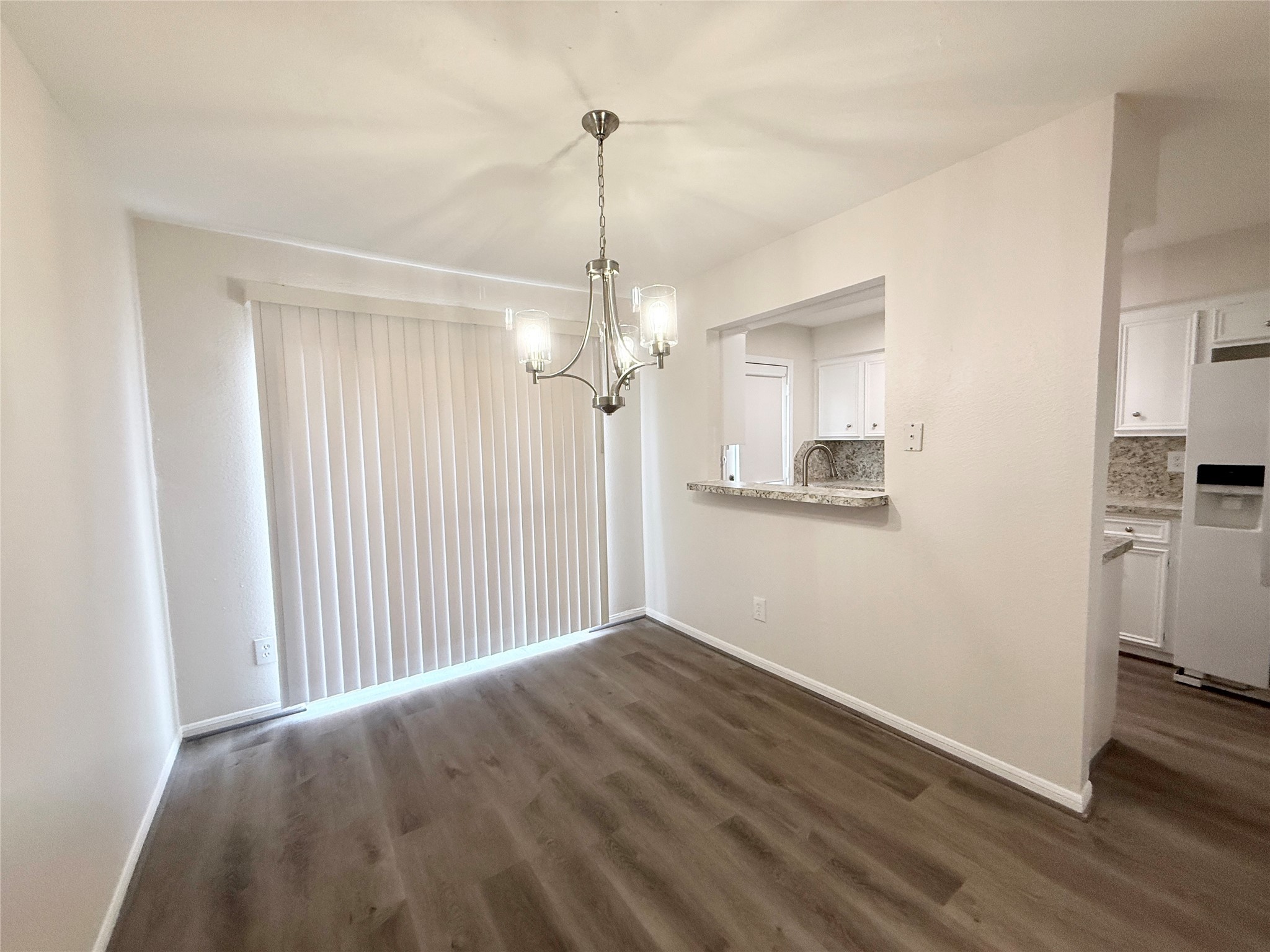 1477 Springrock Lane, Unit 12 Houston, TX 77055 - Photo 8 of 24 a view of a room with wooden floor a ceiling fan and kitchen space