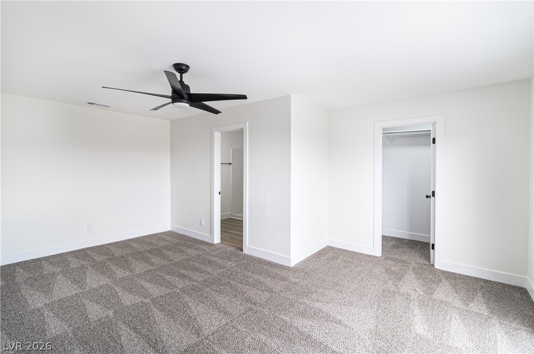 1891 Brian Road Pahrump, NV 89048 - Photo 28 of 50 Unfurnished bedroom featuring ceiling fan, baseboards, carpet floors, and a walk in closet
