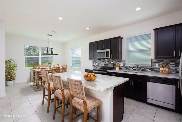 a kitchen with a sink stove and chairs