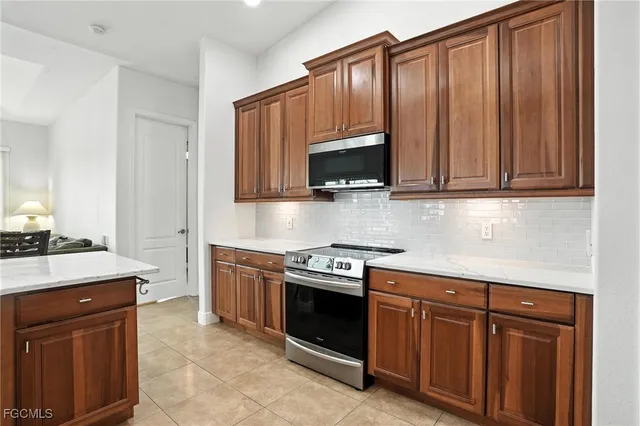 a kitchen with granite countertop wooden cabinets and stainless steel appliances