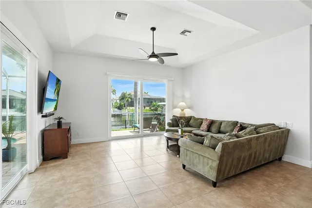 a living room with furniture a flat screen tv and a large window