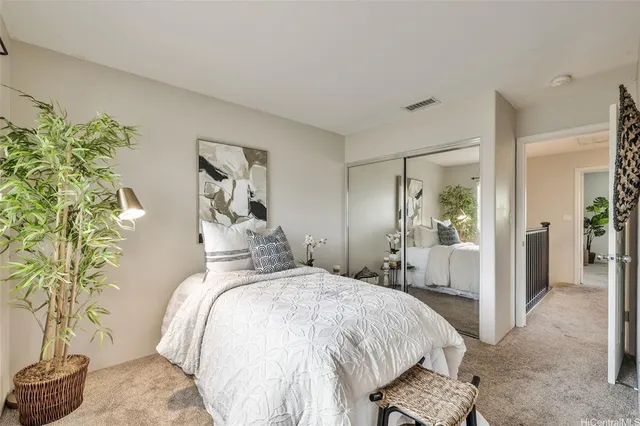 a bedroom with a bed and a potted plant