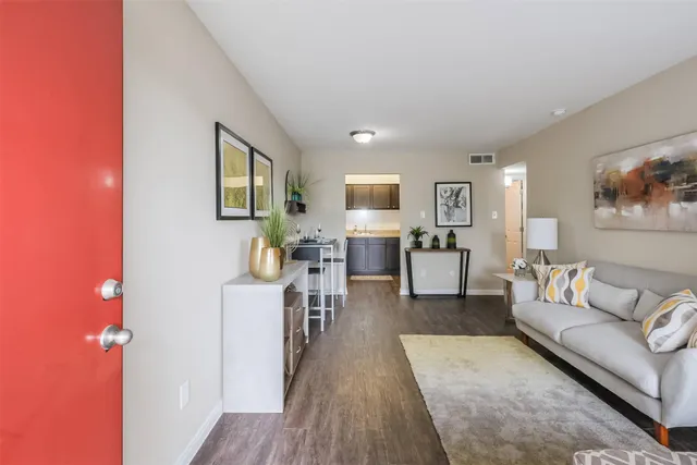 a living room with furniture and a wooden floor