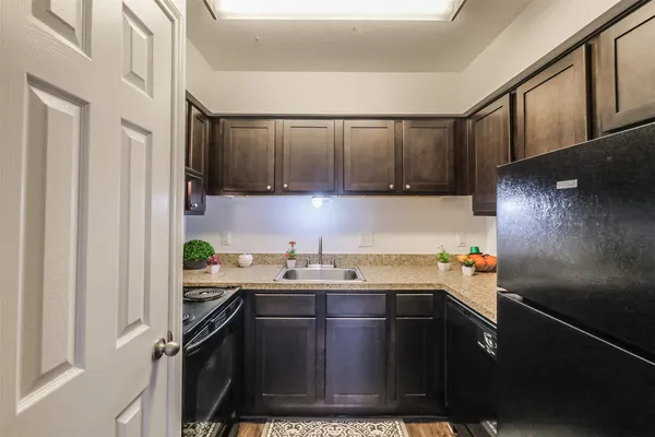 a kitchen with a sink a refrigerator and cabinets