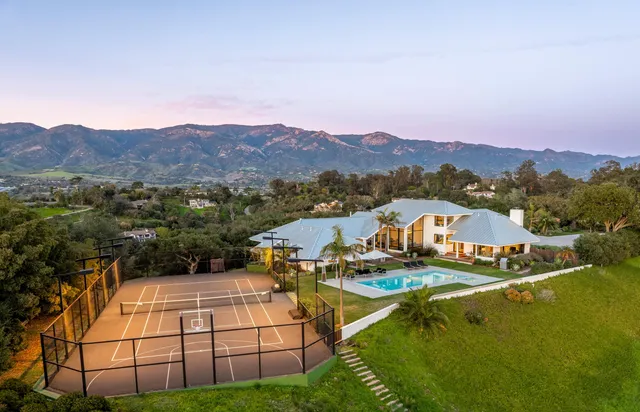 a living room with furniture large window and a chandelier