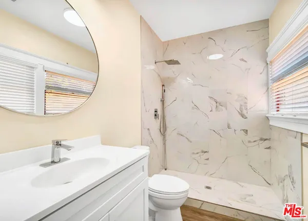 a bathroom with a sink toilet vanity and shower