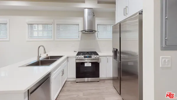 a kitchen with stainless steel appliances granite countertop a sink and a refrigerator