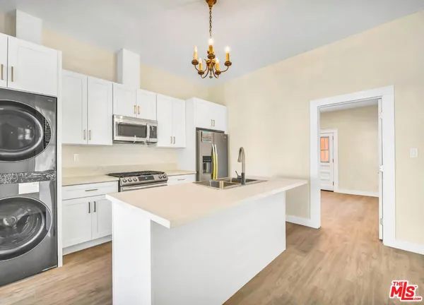 a kitchen with kitchen island a stove a sink and a refrigerator