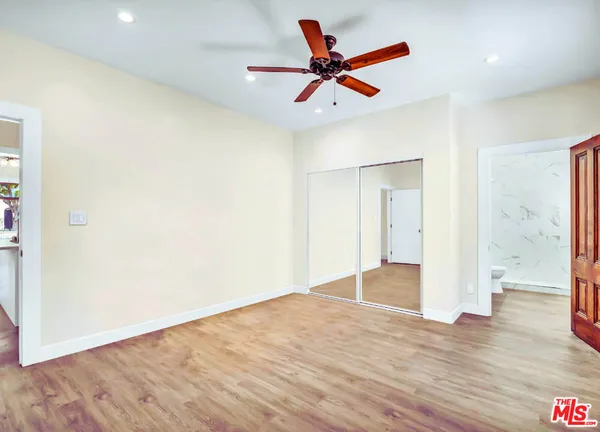 a view of a big room with wooden floor and a ceiling fan