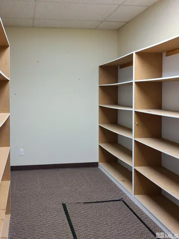 a view of an empty room with window and stairs